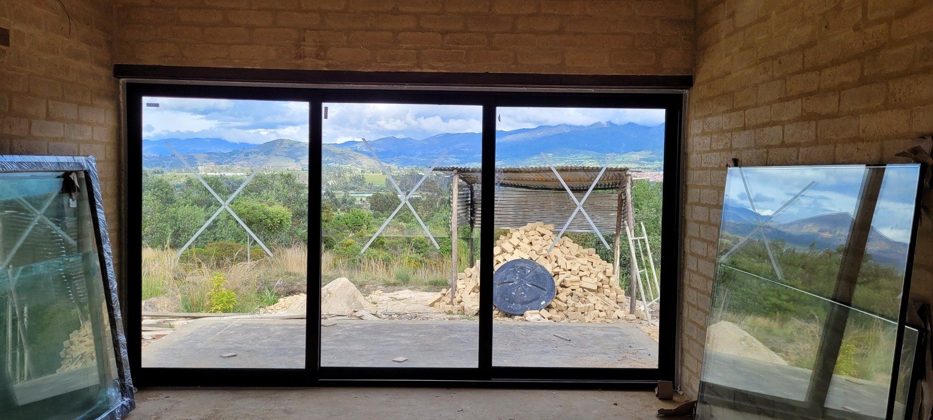 Una habitación con muchas ventanas y vistas a las montañas.