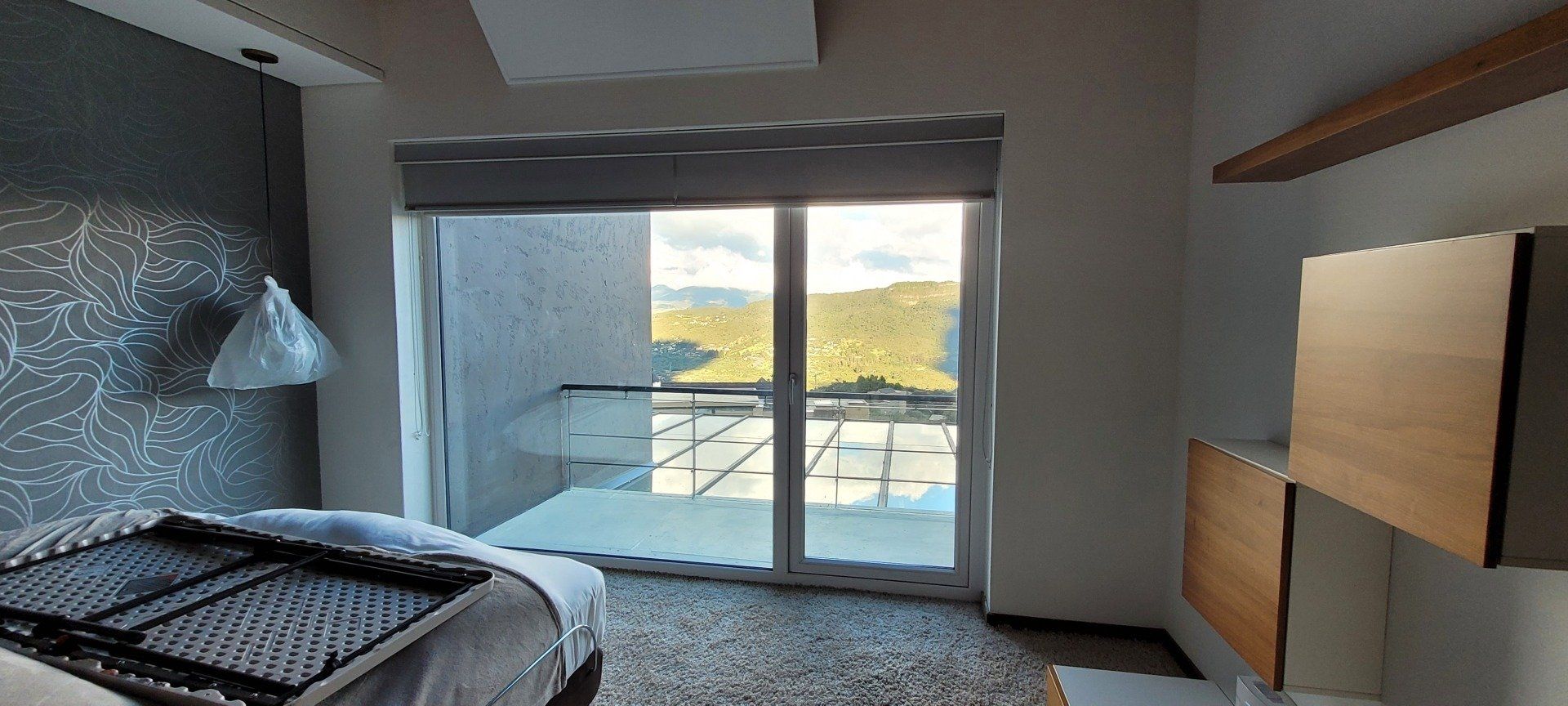 Un dormitorio con una cama y una puerta corrediza de vidrio que conduce a un balcón.