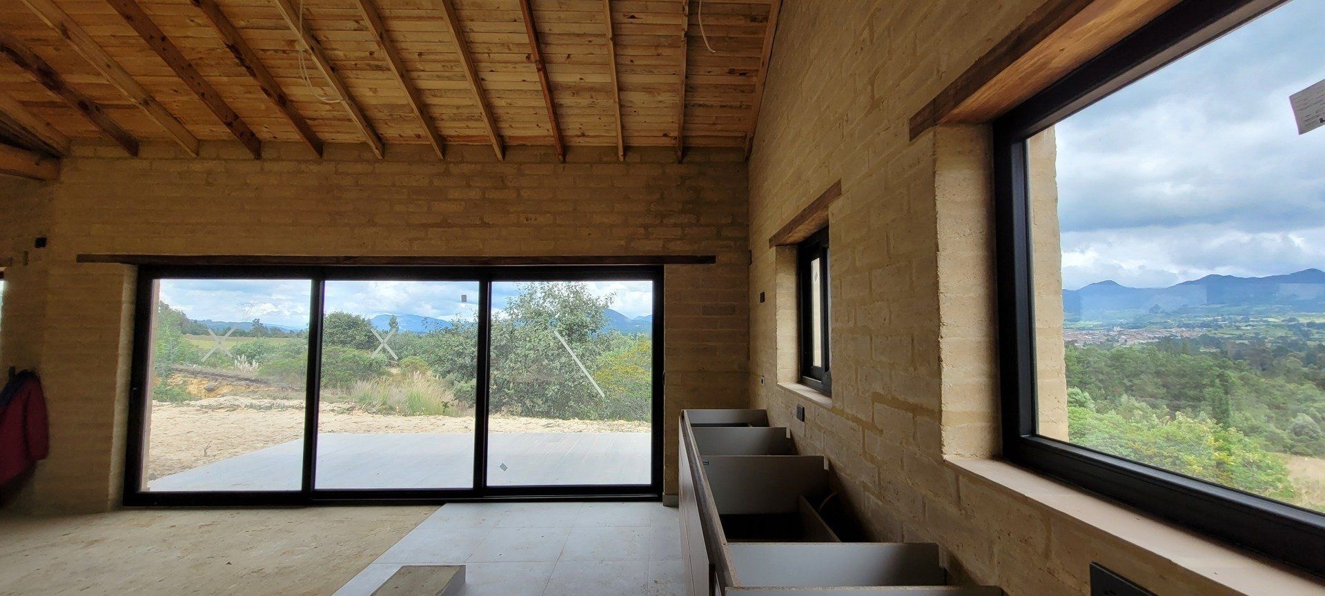Una habitación con muchas ventanas y techo de madera.