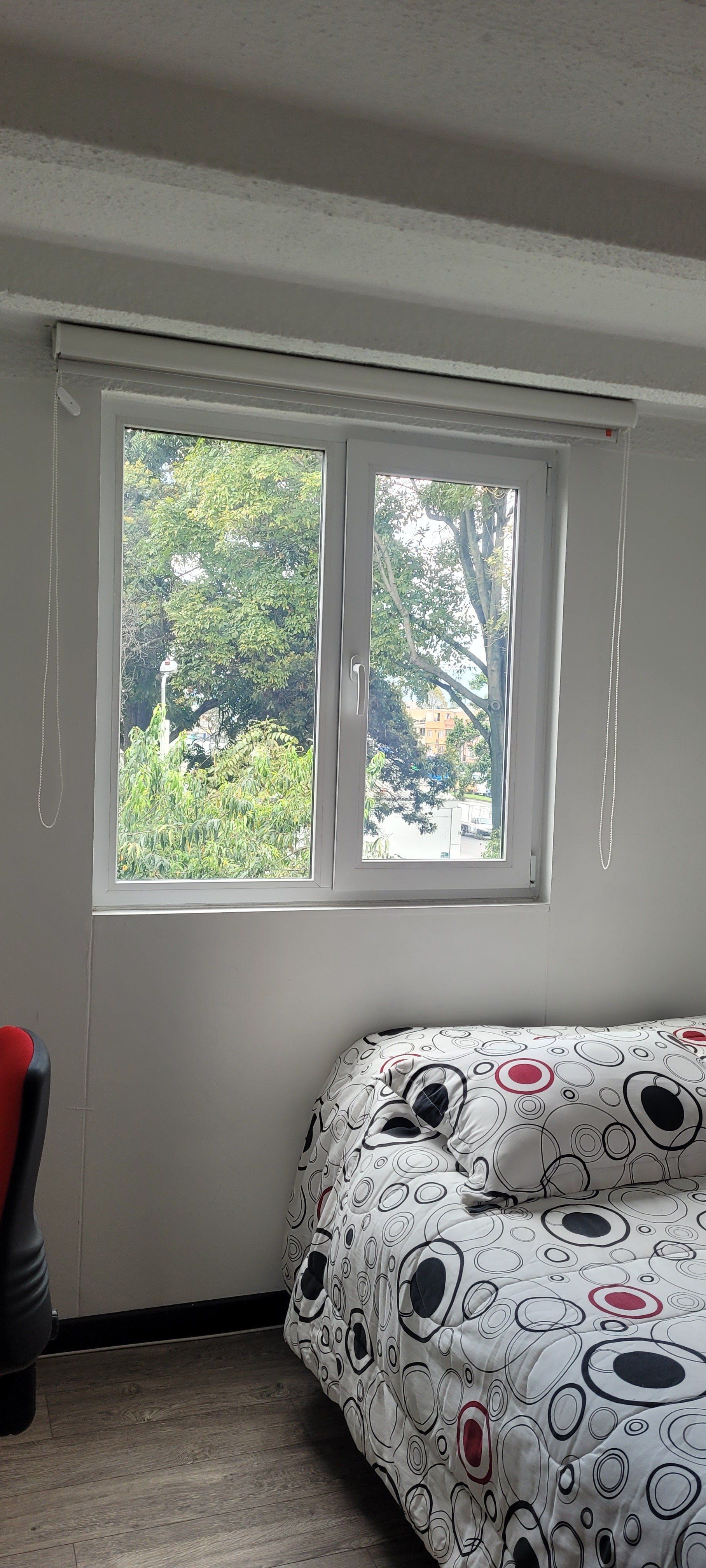 Un dormitorio con una cama y una ventana con persianas.