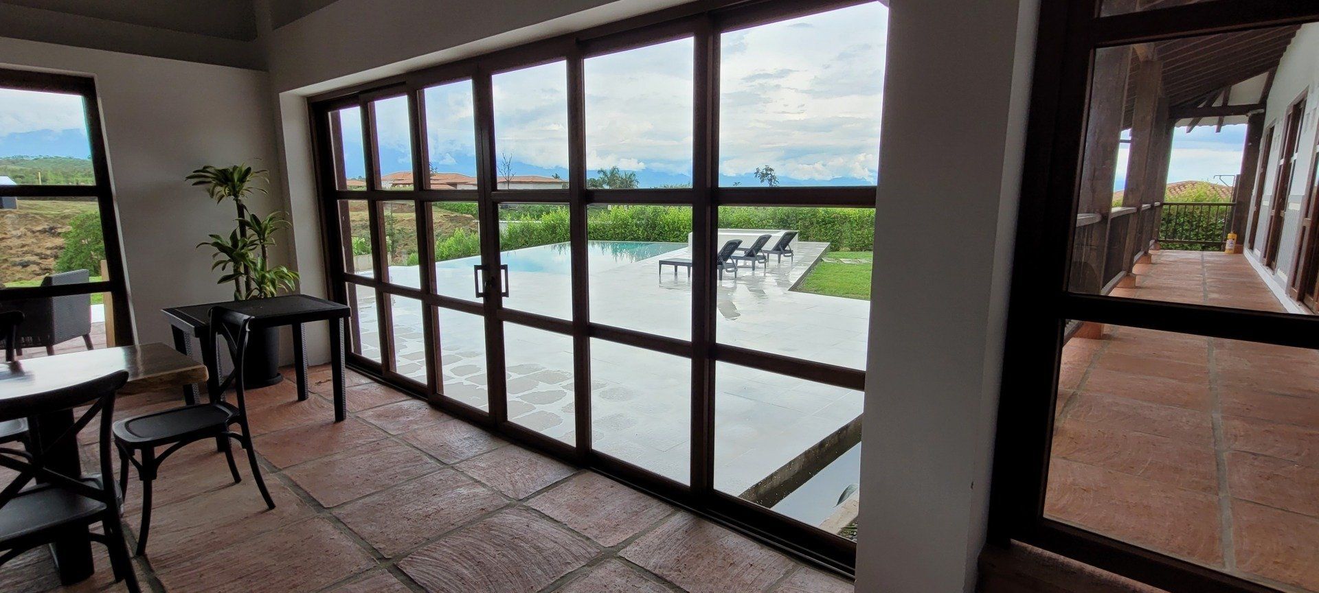 Una habitación con muchas ventanas y vistas a una piscina.
