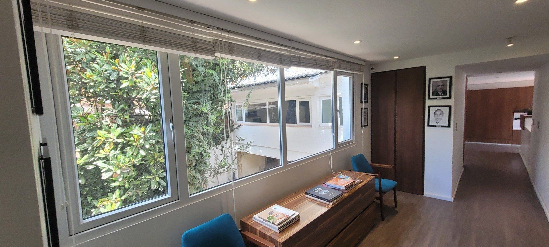 Una habitación con muchas ventanas y una mesa y sillas.