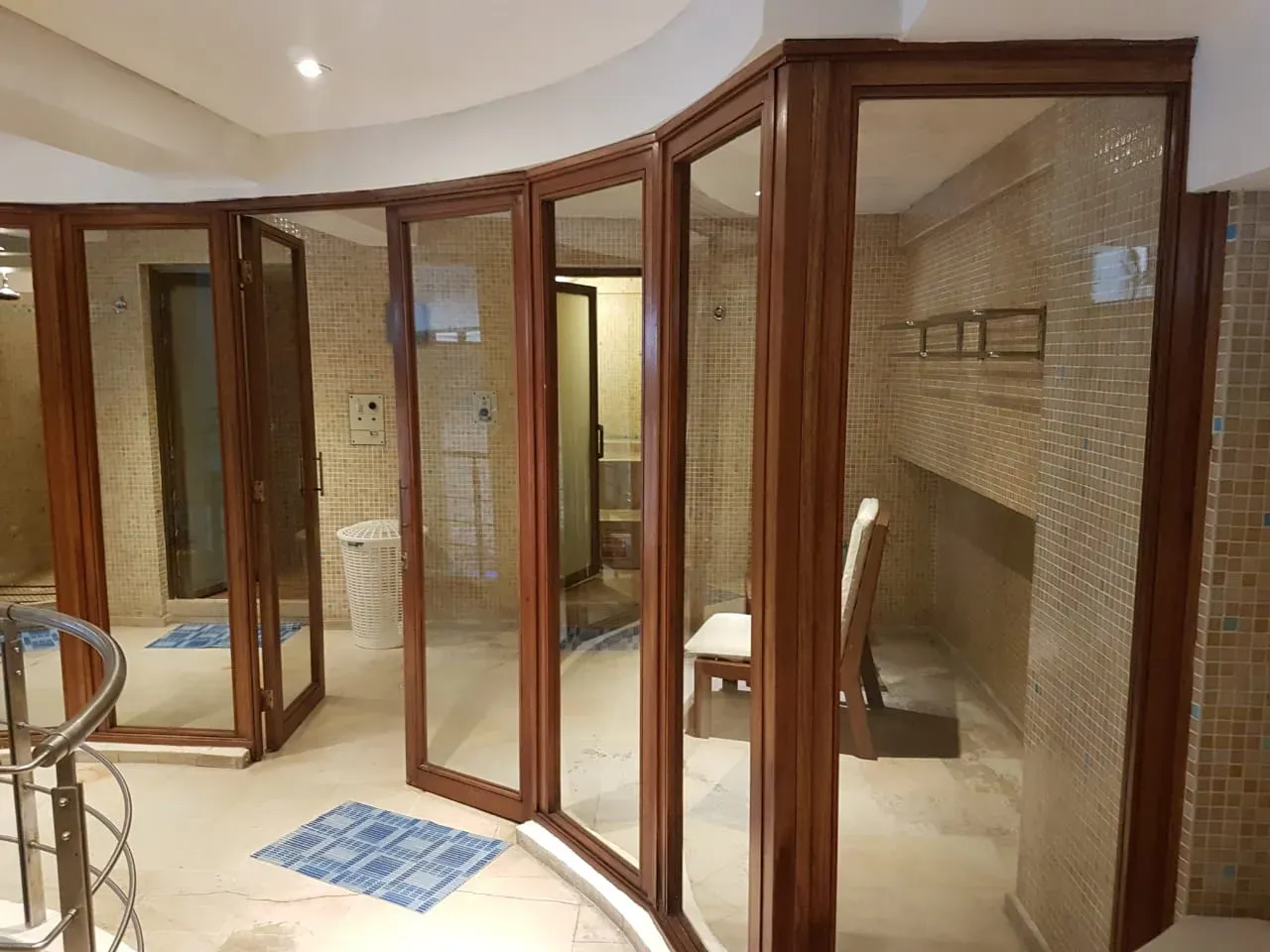 Una habitación con muchas puertas de vidrio y una escalera.