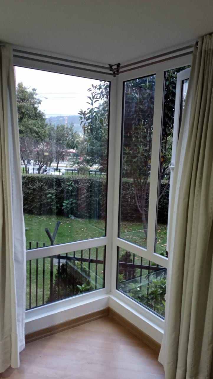 Una habitación con muchas ventanas y cortinas.
