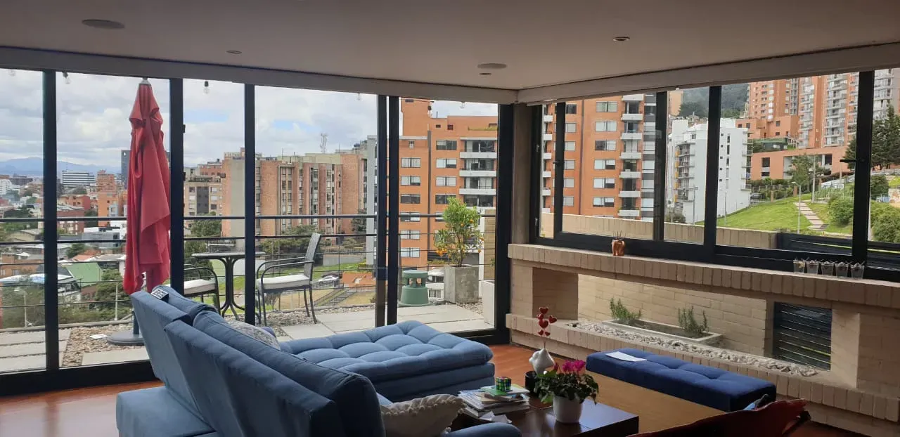Una sala de estar con muchas ventanas y un sofá.