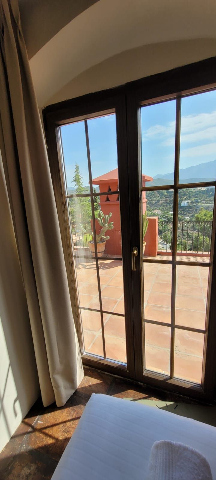 Un dormitorio con vista a un balcón a través de una ventana.