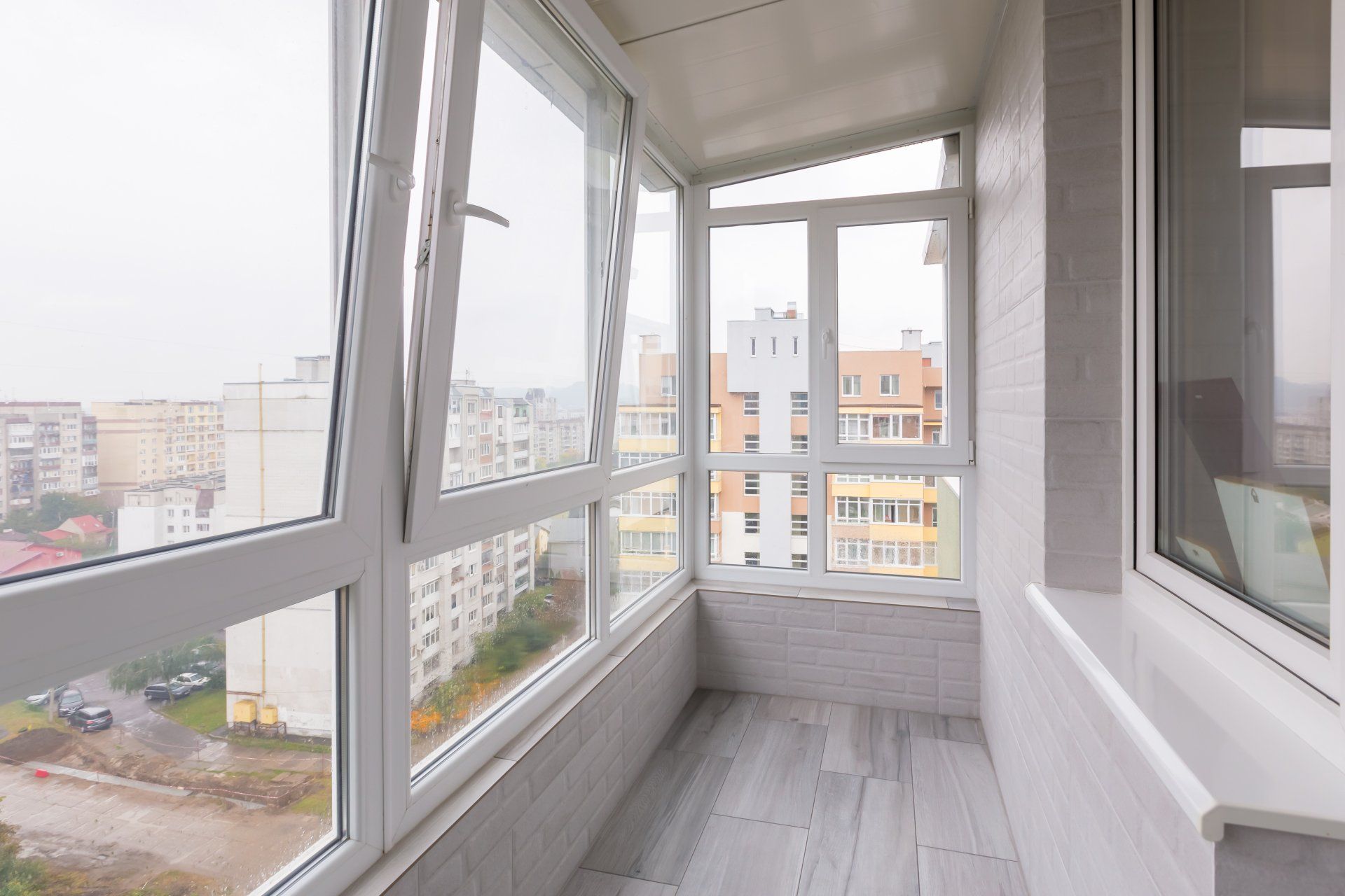 Un balcón con muchas ventanas y vista a la ciudad.