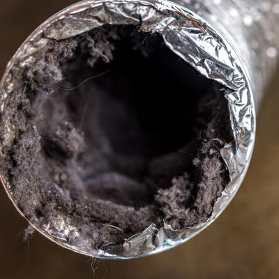 a close up of a dirty air duct with a hole in it