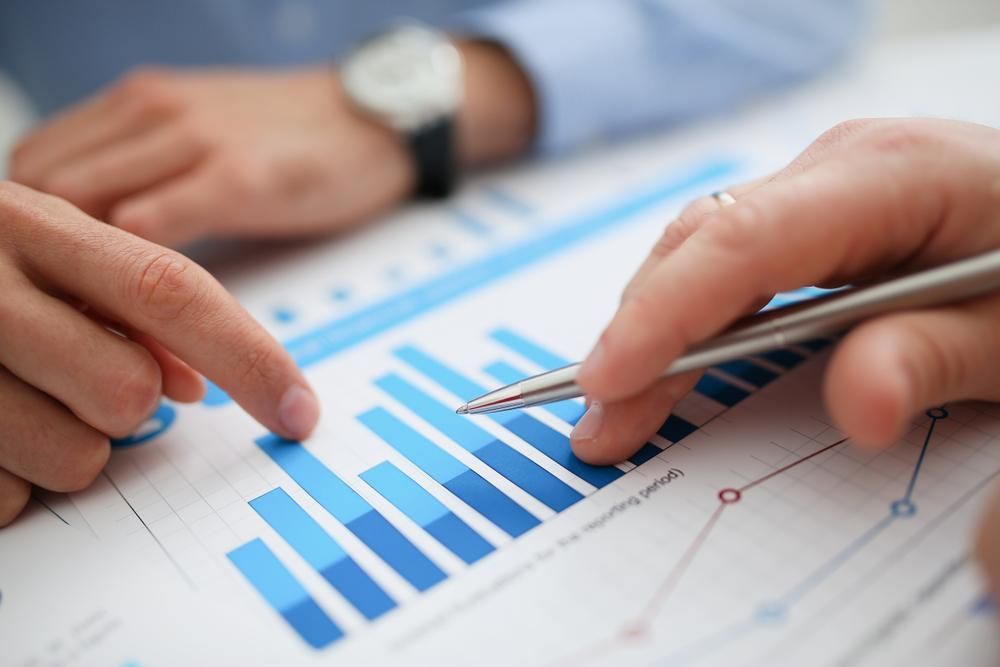 A Person Is Pointing at A Graph on A Piece of Paper with A Pen — Cape York Accounting Smithfield in Smithfield, QLD