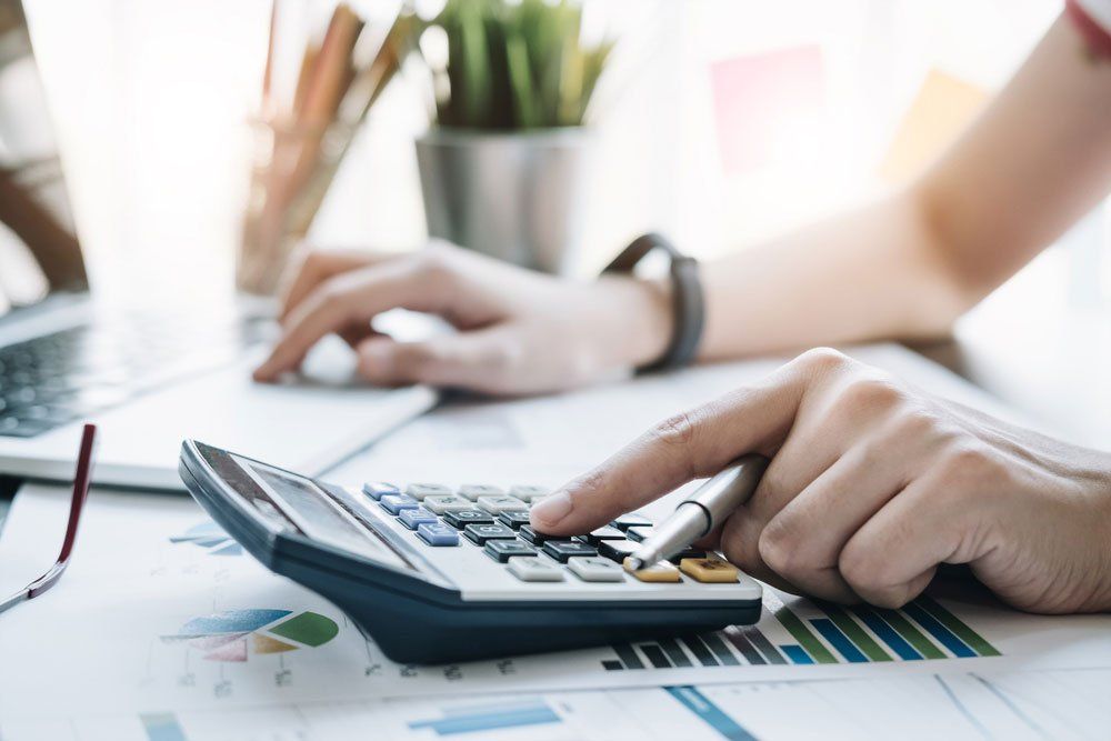 A Person Is Using a Calculator at A Desk — Cape York Accounting Smithfield in Bamaga, QLD