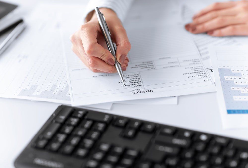 A Person Is Writing on A Piece of Paper with A Pen — Cape York Accounting Smithfield in Smithfield, QLD