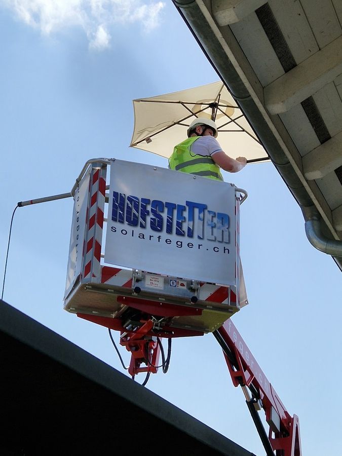Ein Mann in einer Hebebühne auf dem das Wort Hofsteiner abgebildet ist