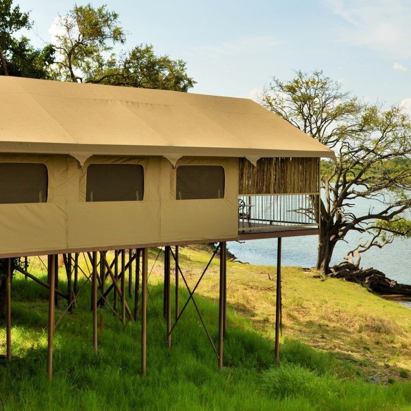 One of the tents at Jackalberry Lodge in Botswana is captured in this evocative travel photograph, set within the lush, wildlife-rich environment of the Moremi Game Reserve. The tent’s canvas walls and natural materials blend seamlessly with the surrounding trees and floodplain, creating a sense of harmony with the bush. Elevated walkways and private decks provide intimate spaces for guests to observe the local wildlife and soak in the serene landscape. The design emphasizes understated comfort while maintaining a close connection to nature, allowing visitors to experience authentic safari living. This setting reflects the lodge’s focus on privacy, tranquility, and immersive encounters with Botswana’s extraordinary wilderness. Inspiration Africa specializes in bespoke, tailor-made journeys to Botswana and across Africa, crafting unforgettable safari experiences in remarkable and remote destinations.