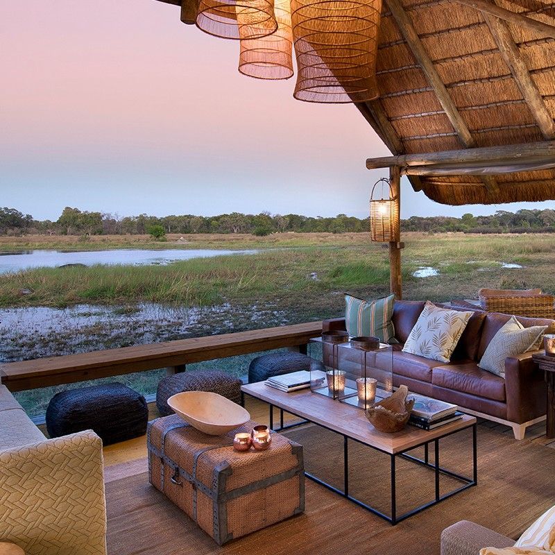A serene veranda overlooking the natural surroundings of Sable Alley Lagoon in Botswana at sunset is captured in this evocative travel photograph, highlighting a moment of peaceful connection with the wilderness. Soft golden light bathes the deck, reflecting on the calm waters of the lagoon and illuminating the surrounding reeds, trees, and wildlife. Comfortable seating and open design create an inviting space to relax and immerse in the tranquil beauty of the Okavango Delta ecosystem. The scene emphasizes the lodge’s thoughtful positioning and harmonious integration with its environment, offering guests unforgettable sunset views. Inspiration Africa curates bespoke, tailor-made journeys to Botswana and across Africa, combining luxurious lodge stays with immersive wildlife and nature experiences.