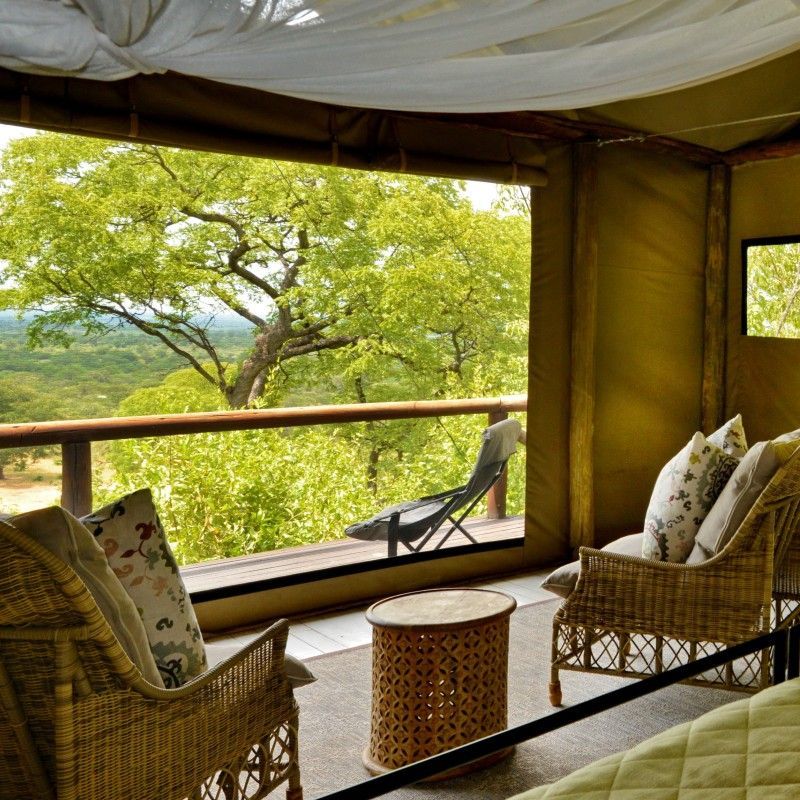 A balcony at Ghoha Hills Lodge in Botswana overlooking lush trees and natural landscapes is captured in this tranquil travel photograph, highlighting a peaceful retreat immersed in the wilderness. Comfortable seating and open design allow guests to enjoy unobstructed views of the surrounding bush, listening to the sounds of birds and wildlife as sunlight filters through the foliage. The scene emphasizes the lodge’s harmonious integration with its environment, offering an intimate connection with Botswana’s natural beauty. Inspiration Africa curates bespoke, tailor-made journeys to Botswana and across Africa, combining luxurious lodge stays with immersive wildlife encounters and unforgettable safari experiences.