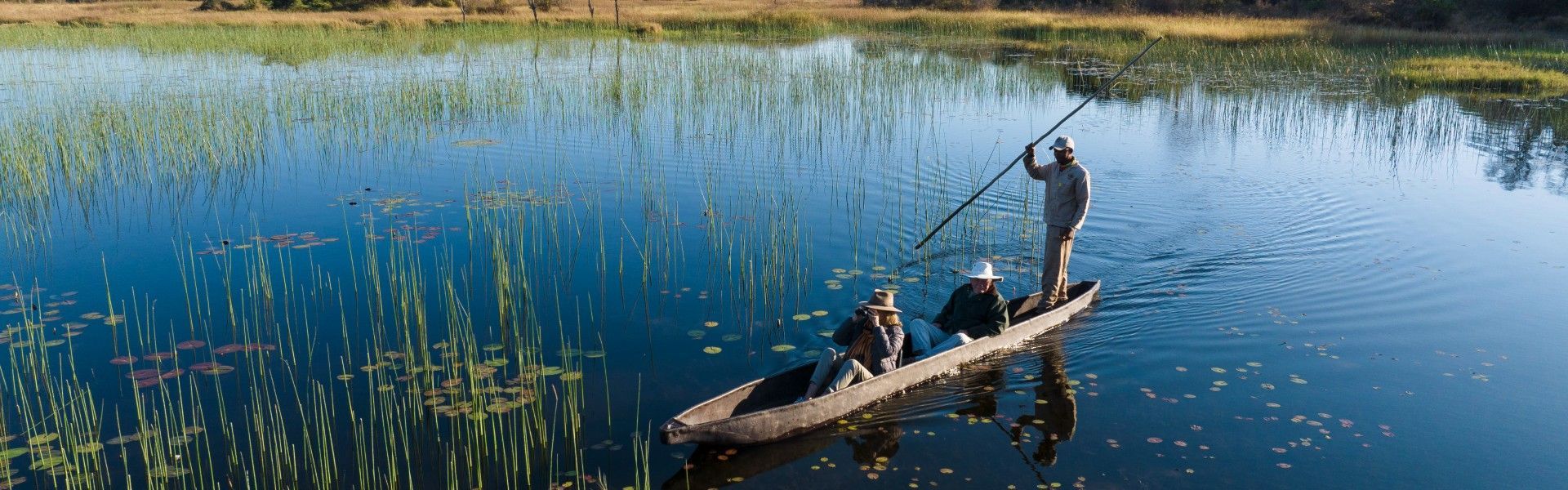 Drift quietly through the pristine waterways of Botswana’s Okavango Delta on a traditional wooden mokoro, captured in this evocative safari photograph. A skilled local guide poles the canoe through crystal-clear channels lined with papyrus reeds and water lilies, offering an intimate perspective on one of Africa’s most iconic wetland ecosystems. Renowned for its rich wildlife, tranquil scenery, and immersive safari experiences, the Okavango Delta is a UNESCO World Heritage Site and a highlight of any African journey. Exploring this unique landscape by mokoro allows travelers to connect deeply with nature, spotting wildlife at water level in serene surroundings. Inspiration Africa specializes in creating bespoke, tailor-made safaris that showcase authentic experiences in Botswana and across Africa’s most extraordinary destinations.