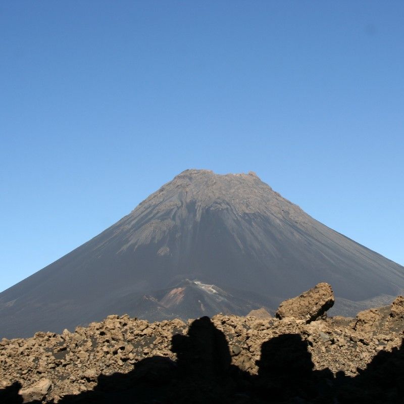 Adventurers trek across the rugged volcanic slopes of Pico do Fogo in Cape Verde, captured in this dramatic travel photograph. As the highest peak in the archipelago, Pico do Fogo offers sweeping views of lava fields, crater rims, and the surrounding islands, creating a striking and unforgettable trekking experience. Trails wind through volcanic landscapes, fertile valleys, and small local villages, allowing travelers to experience both natural beauty and Cape Verdean culture. Ideal for adventure seekers, hikers, and photographers, trekking Pico do Fogo combines physical challenge, stunning scenery, and immersive exploration of one of Africa’s most unique volcanic destinations. Inspiration Africa specializes in bespoke, tailor-made journeys to Cape Verde and across Africa, crafting authentic, unforgettable adventure experiences in extraordinary destinations.