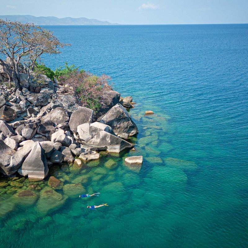 Experience the tranquil beauty of Lake Malawi with this stunning image of a sunlit sandy beach meeting the calm, crystal-clear blue waters. Under a bright azure sky, the shoreline stretches peacefully along the lake, with gentle waves lapping at the sand and creating a serene, inviting atmosphere. The clarity of the water and the soft tones of the beach evoke a sense of relaxation and natural simplicity, showcasing one of Africa’s most beautiful freshwater destinations, renowned for its warm waters and unspoiled charm.
Inspiration Africa specializes in bespoke, tailor-made journeys across Africa, crafting unforgettable experiences for every type of traveller. Let us design your personalized escape to Lake Malawi, where families can unwind on safe, sandy beaches, enjoy swimming in calm waters, and experience quality time together in a peaceful lakeside setting surrounded by natural beauty.
