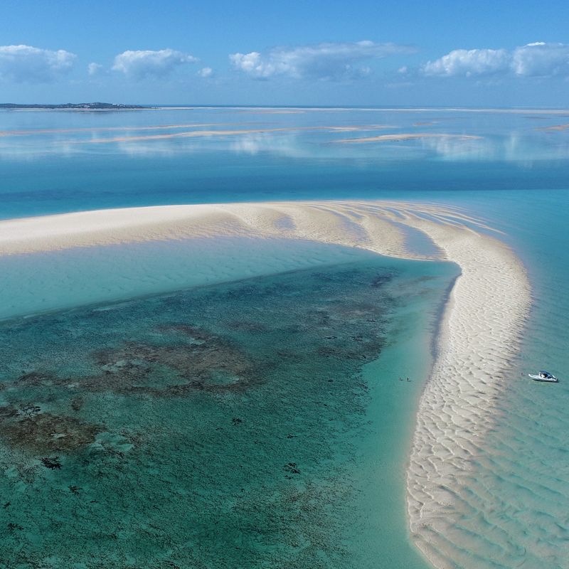 Discover this immaculate sandbank off the coast of Mozambique in this captivating aerial photo. The dazzling, beautiful white coral sand provides a striking contrast to the Indian Ocean's dynamic colors, ranging from shallow, clear turquoise to the mysterious deep sea blue. This pristine spot is the perfect setting for relaxation and exploration. Inspiration Africa specializes in designing your luxurious, tailor-made trip to Mozambique and a host of other extraordinary destinations across Africa. Plan your ultimate beach holiday with us today