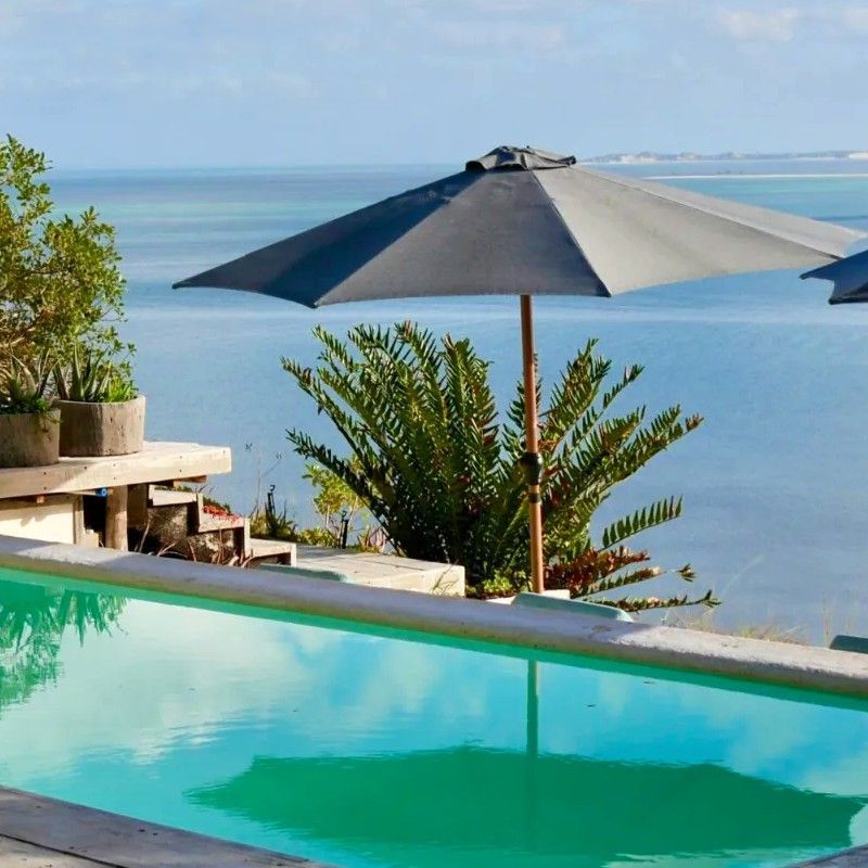 Certainly — here’s a polished, SEO-friendly alt text in the same style:
The swimming pool at Azulik Lodge in Mozambique is captured in this serene travel photograph, highlighting a peaceful coastal retreat immersed in nature. Surrounded by tropical greenery and natural materials, the pool blends seamlessly into the lodge’s eco-inspired design, creating a sense of privacy and relaxation. Soft natural light reflects on the water’s surface, enhancing the calm atmosphere and inviting guests to unwind after a day of exploration. The scene emphasizes Azulik Lodge’s harmony with its surroundings and its focus on barefoot luxury and tranquility. Inspiration Africa curates bespoke, tailor-made journeys to Mozambique and across Africa, combining luxury beach stays with immersive coastal and cultural experiences.

