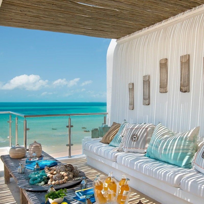 One of the balconies at Santorini Mozambique in Vilanculos is captured in this stunning travel photograph, showcasing a private space overlooking the turquoise waters of the Indian Ocean. The balcony features comfortable seating and natural wooden accents, offering guests an intimate spot to relax while taking in sweeping views of the coastline, shimmering waves, and distant islands. Gentle sunlight and soft coastal breezes enhance the sense of tranquility and connection to the surrounding seascape. The scene conveys peace, understated luxury, and a seamless blend of comfort with Mozambique’s spectacular ocean vistas, highlighting Santorini Mozambique as an idyllic retreat in Vilanculos. Inspiration Africa specializes in bespoke, tailor-made journeys to Mozambique and across Africa, crafting unforgettable travel experiences in extraordinary destinations.
