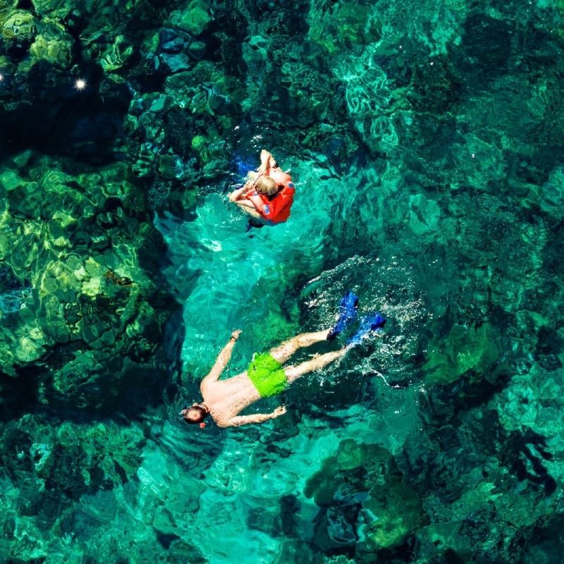 An aerial view captures two snorkelers exploring a vibrant coral reef in the stunning turquoise waters of Vilanculos, Mozambique, in this breathtaking marine travel photograph. From above, the reef’s intricate coral formations and schools of tropical fish are clearly visible, highlighting the richness and diversity of this pristine marine ecosystem. Vilanculos, gateway to the Bazaruto Archipelago, is renowned for its crystal-clear waters, abundant marine life, and exceptional snorkeling and diving opportunities. Ideal for snorkelers, marine wildlife enthusiasts, and photographers, this scene captures the beauty, clarity, and serenity of Mozambique’s Indian Ocean waters. Inspiration Africa specializes in bespoke, tailor-made journeys to Mozambique and across Africa, crafting immersive coastal experiences and unforgettable underwater wildlife encounters in extraordinary destinations.