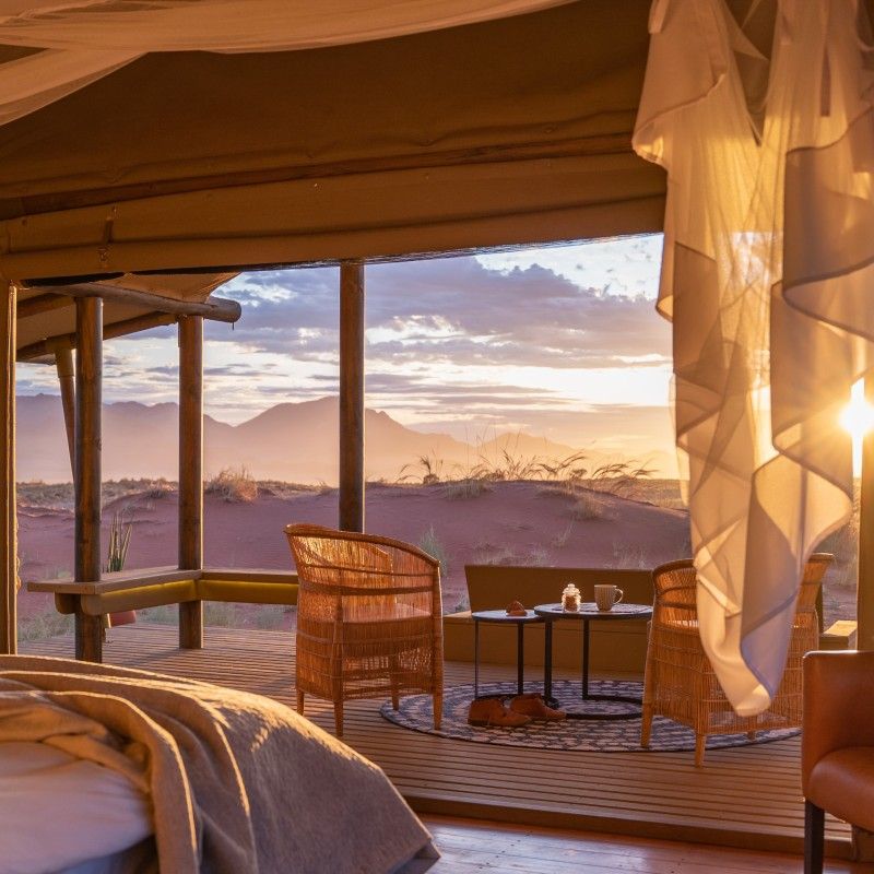 The beautifully designed rooms at Wolwedans Dune Camp in Namibia are showcased in this evocative travel photograph, offering an intimate blend of comfort, simplicity, and desert elegance. Elevated above the dunes, the rooms feature natural materials, handcrafted furnishings, and soft, earthy tones that mirror the surrounding NamibRand landscape. Open layouts and wide windows create a strong sense of space and connection to the vast desert beyond, allowing light, air, and sweeping views to define the experience. The rooms reflect Wolwedans’ commitment to sustainability, authenticity, and understated luxury, providing a peaceful retreat immersed in one of the world’s most striking desert environments. Ideal for travelers seeking seclusion, design-led accommodation, and a deep connection to nature, this scene captures the tranquility and timeless beauty of Wolwedans Dune Camp. Inspiration Africa specializes in bespoke, tailor-made journeys to Namibia and across Africa, crafting unforgettable desert stays and immersive wilderness experiences.