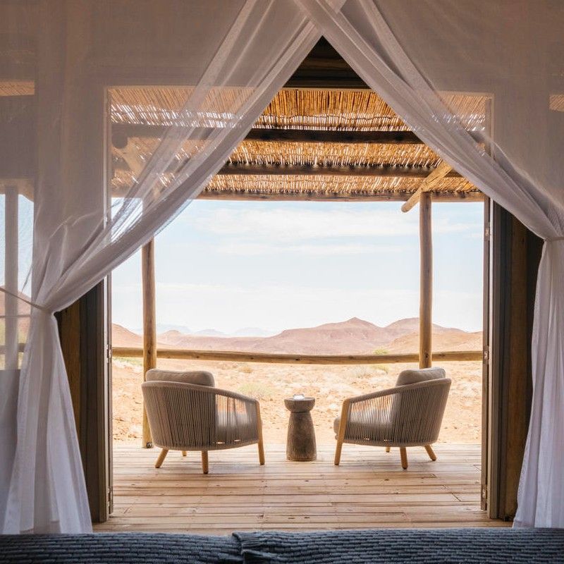 The balcony at Wilderness Damaraland Camp in Namibia is captured in this breathtaking travel photograph, offering sweeping views over the rugged, arid landscapes of Damaraland. From this elevated vantage point, guests can take in dramatic rock formations, expansive plains, and the ever-changing colors of the desert under wide-open skies. The balcony’s comfortable seating and thoughtful design create a perfect space for relaxation, wildlife observation, or simply soaking in the tranquility of this remote wilderness. Ideal for safari enthusiasts, photographers, and travelers seeking solitude and connection with nature, this scene captures the sense of scale, serenity, and natural beauty that define Wilderness Damaraland Camp. Inspiration Africa specializes in bespoke, tailor-made journeys to Namibia and across Africa, crafting immersive safari experiences and unforgettable lodge stays in extraordinary landscapes.