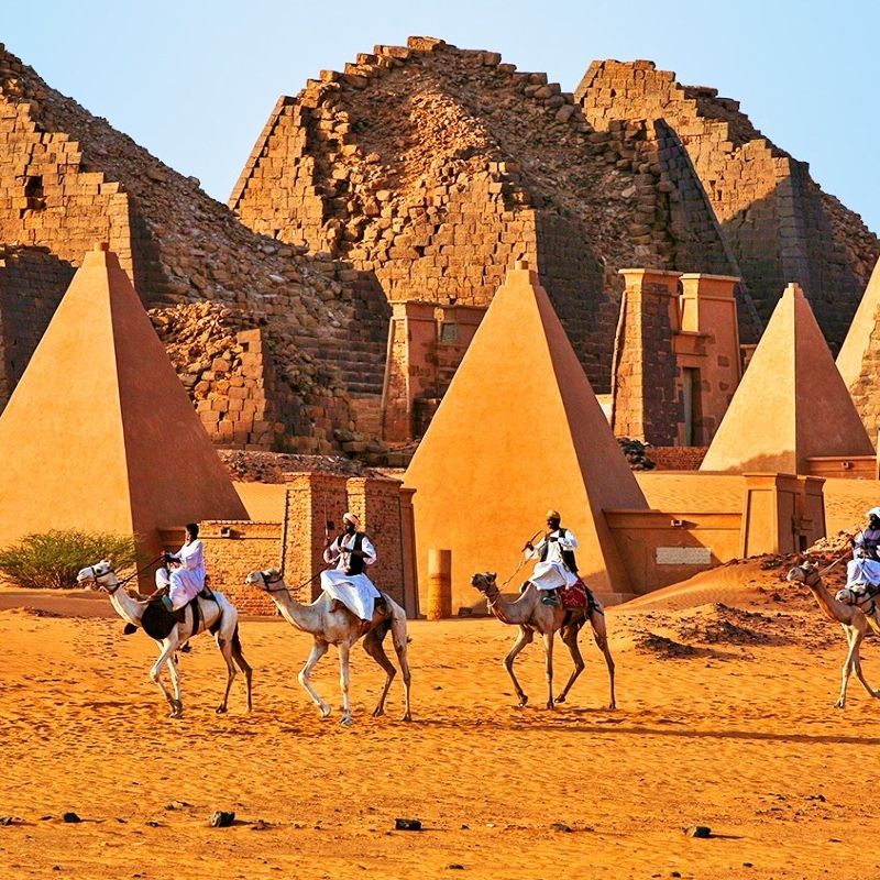 Discover the ancient grandeur of Sudan with this striking image of the Meroe Pyramids, rising from the golden desert sands under a clear sky. These lesser-known Nubian pyramids, with their steep angles and historic significance, offer a fascinating glimpse into the Kingdom of Kush and its remarkable architectural legacy. The surrounding landscape of rolling dunes and sparse vegetation highlights the remote and timeless character of this archaeological treasure.
Inspiration Africa crafts tailor-made journeys to Sudan, giving travellers the opportunity to explore the Meroe Pyramids and other historic sites, combining adventure, culture, and the rich heritage of one of Africa’s most captivating destinations.