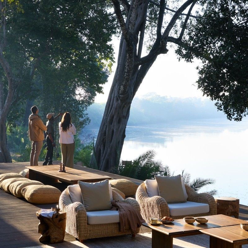 A peaceful riverside deck overlooks the tranquil waters near Lolebezi Safari Lodge in Zambia, offering breathtaking views of the Zambezi River and the surrounding wilderness. Framed by lush vegetation and ancient trees, this inviting setting provides the perfect place to relax, observe wildlife, and immerse yourself in the natural beauty of one of Africa’s most remarkable safari destinations. The combination of luxury, serenity, and spectacular scenery captures the essence of an exclusive safari experience in the heart of the Lower Zambezi. Inspiration Africa specializes in bespoke, tailor-made journeys across Zambia and the African continent, creating immersive travel experiences that combine exceptional wildlife encounters, luxury accommodations, and authentic cultural discovery. From elegant riverside lodges to unforgettable safari adventures, every itinerary is carefully curated to showcase the beauty, diversity, and spirit of Africa.
