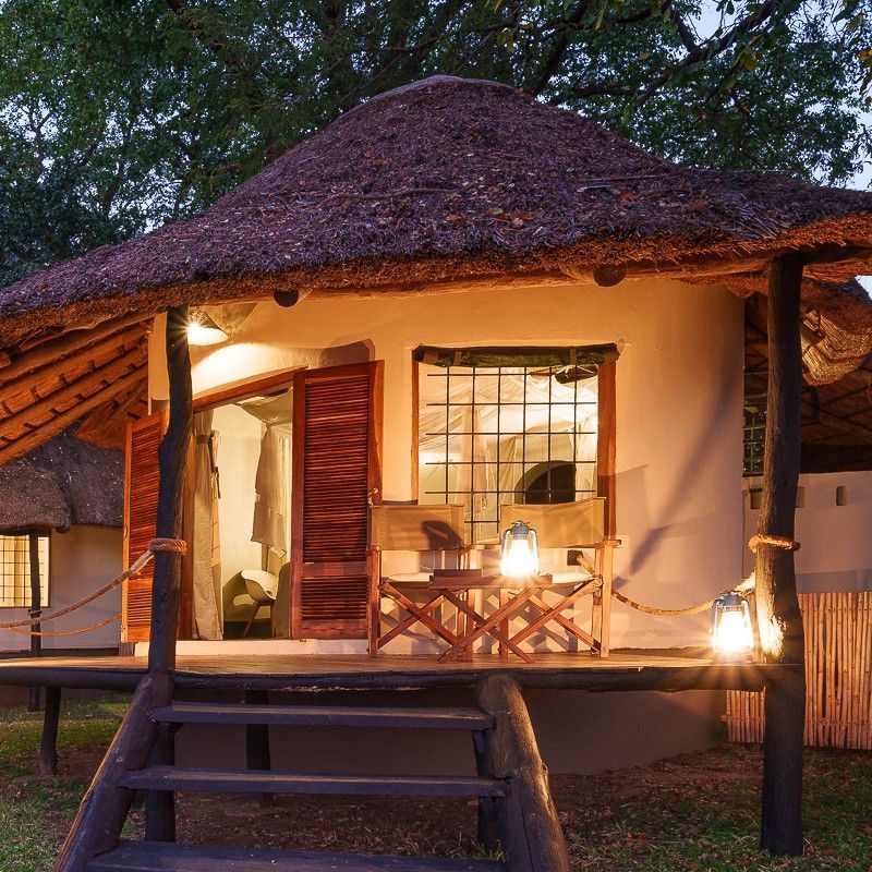 The exterior of Nsefu Camp in Zambia is captured in this atmospheric travel photograph, set within the lush, wildlife-rich landscape of South Luangwa National Park. Canvas tents and natural wooden structures are thoughtfully positioned along the riverbank, blending seamlessly with the surrounding trees, grasses, and riverine vegetation. Elevated decks and open pathways invite guests to experience the sights and sounds of the bush, where elephants, hippos, and a variety of wildlife often roam nearby. The setting reflects a balance of authentic safari living and understated comfort, offering an immersive experience in one of Zambia’s most iconic and wildlife-rich safari destinations. Inspiration Africa specializes in bespoke, tailor-made journeys to Zambia and across Africa, crafting unforgettable safari experiences in extraordinary wilderness destinations.
