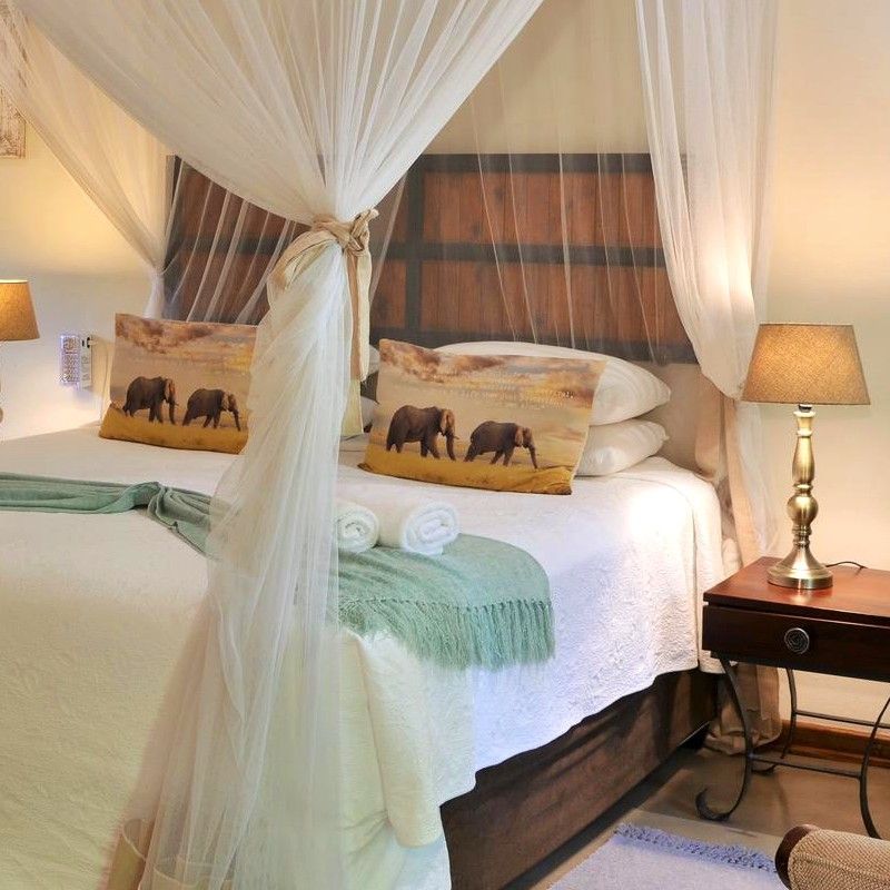 The interior of one of the bedrooms at Bayete Guest Lodge in Victoria Falls, Zimbabwe, is showcased in this inviting travel photograph, highlighting a comfortable and elegantly designed space for relaxation. A well-appointed bed, soft linens, and tasteful furnishings create a warm and welcoming atmosphere, while neutral tones and subtle décor complement the surrounding natural environment. Large windows allow natural light to fill the room and offer views of the lodge grounds, blending indoor comfort with a connection to the outdoors. The interior reflects understated luxury and tranquility, providing guests with a peaceful retreat while exploring the iconic Victoria Falls region. Inspiration Africa specializes in bespoke, tailor-made journeys to Zimbabwe and across Africa, crafting unforgettable travel and safari experiences in extraordinary destinations.