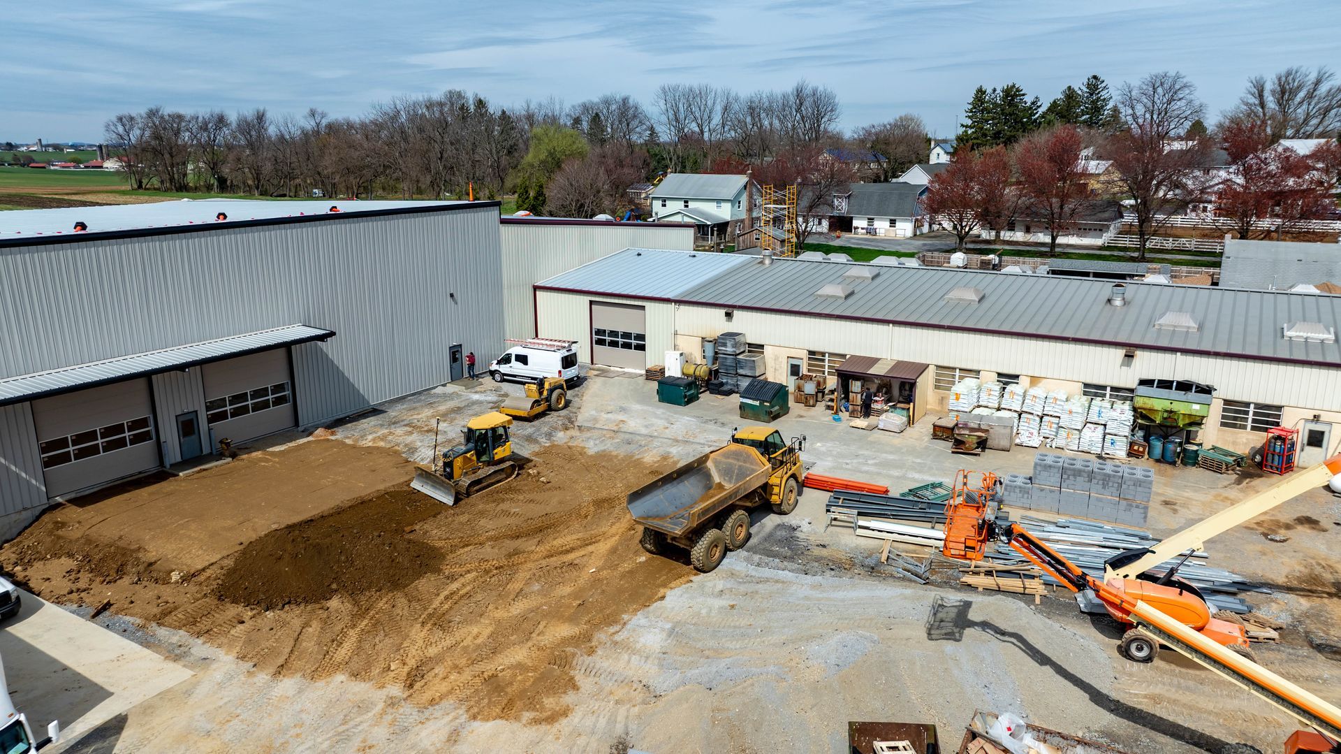 Construction site with heavy machinery like bulldozers, dump truck, and backhoe. Buildings in background. Construction site with heavy machinery like bulldozers, dump truck, and backhoe. Buildings in background.