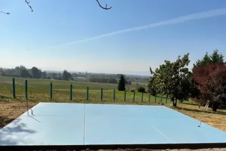 A concrete patio with a view of a field and trees in the background with a sand finish in Salem, OR.