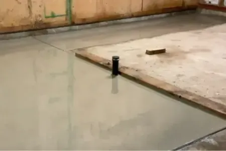 A concrete floor with a pipe in the middle of it with troweled finish in Salem, OR.