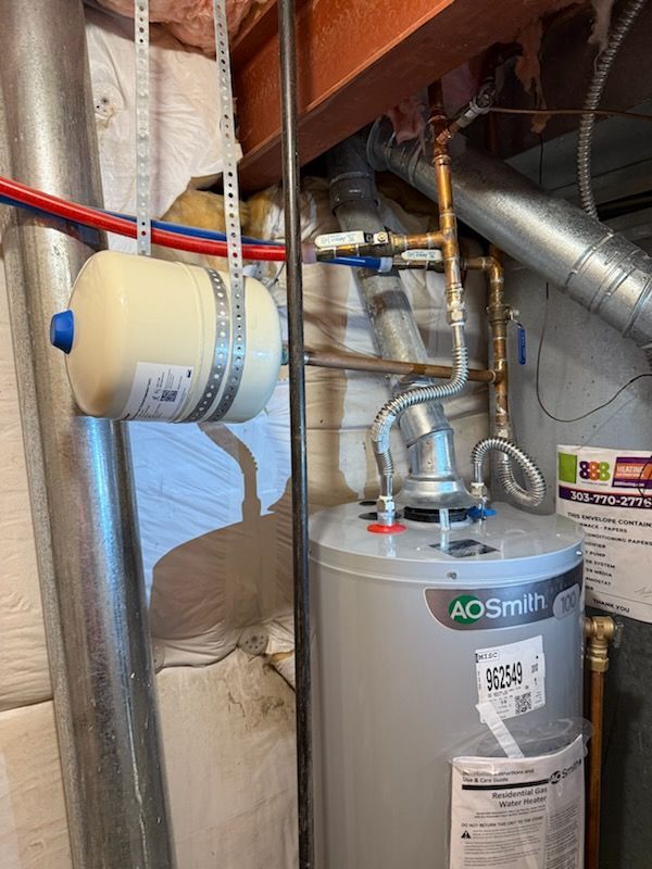 Water heater with pipes and ductwork in a basement utility area