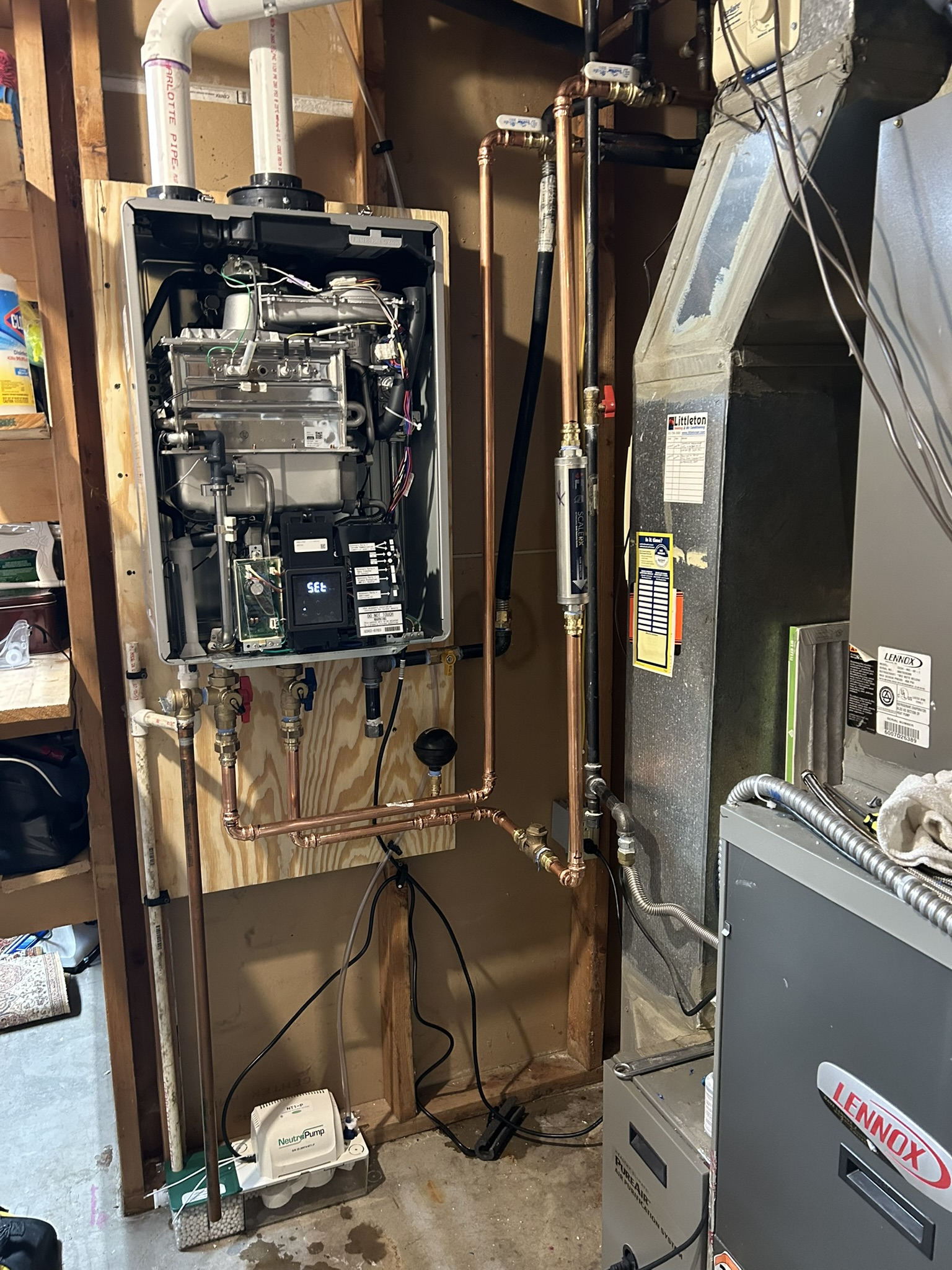 Open electrical panel and exposed wiring in a utility room, with furnace ductwork and equipment nearby