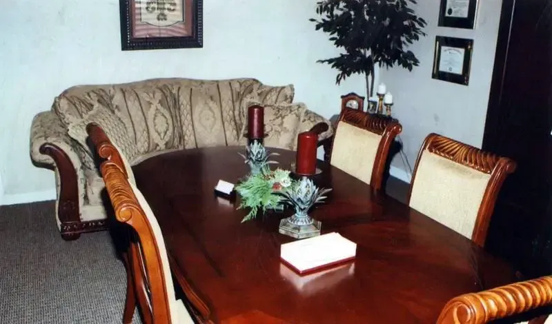 Dining room with a wooden table, upholstered chairs, and a sofa along the wall