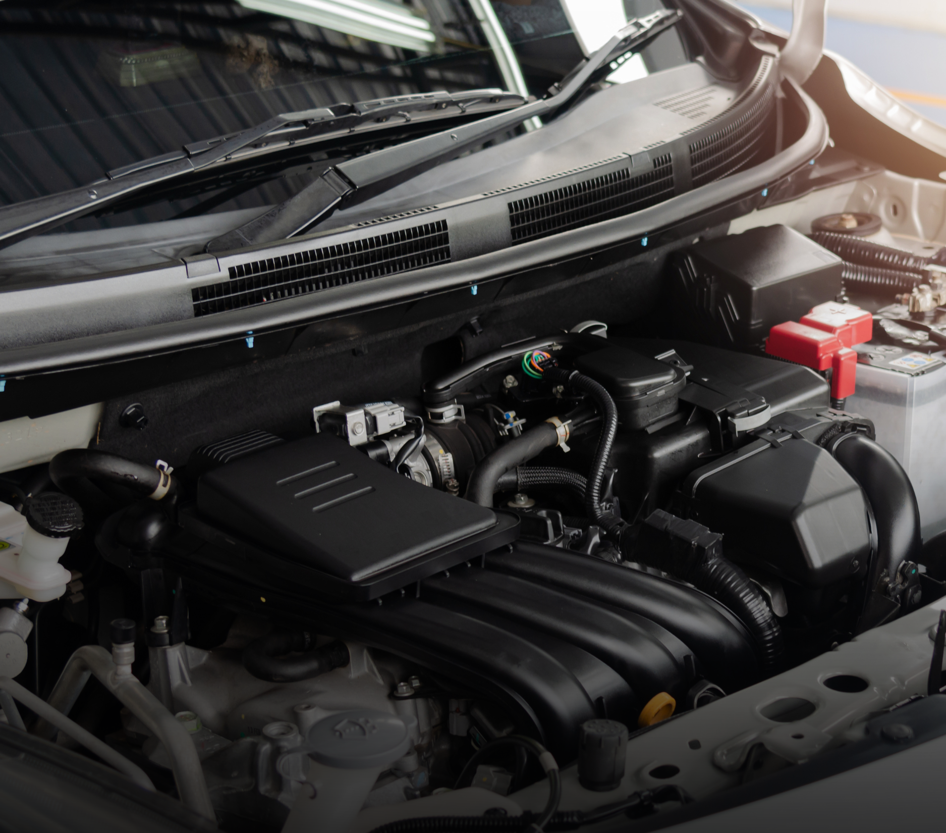 Car engine, black components, battery, viewed from above.