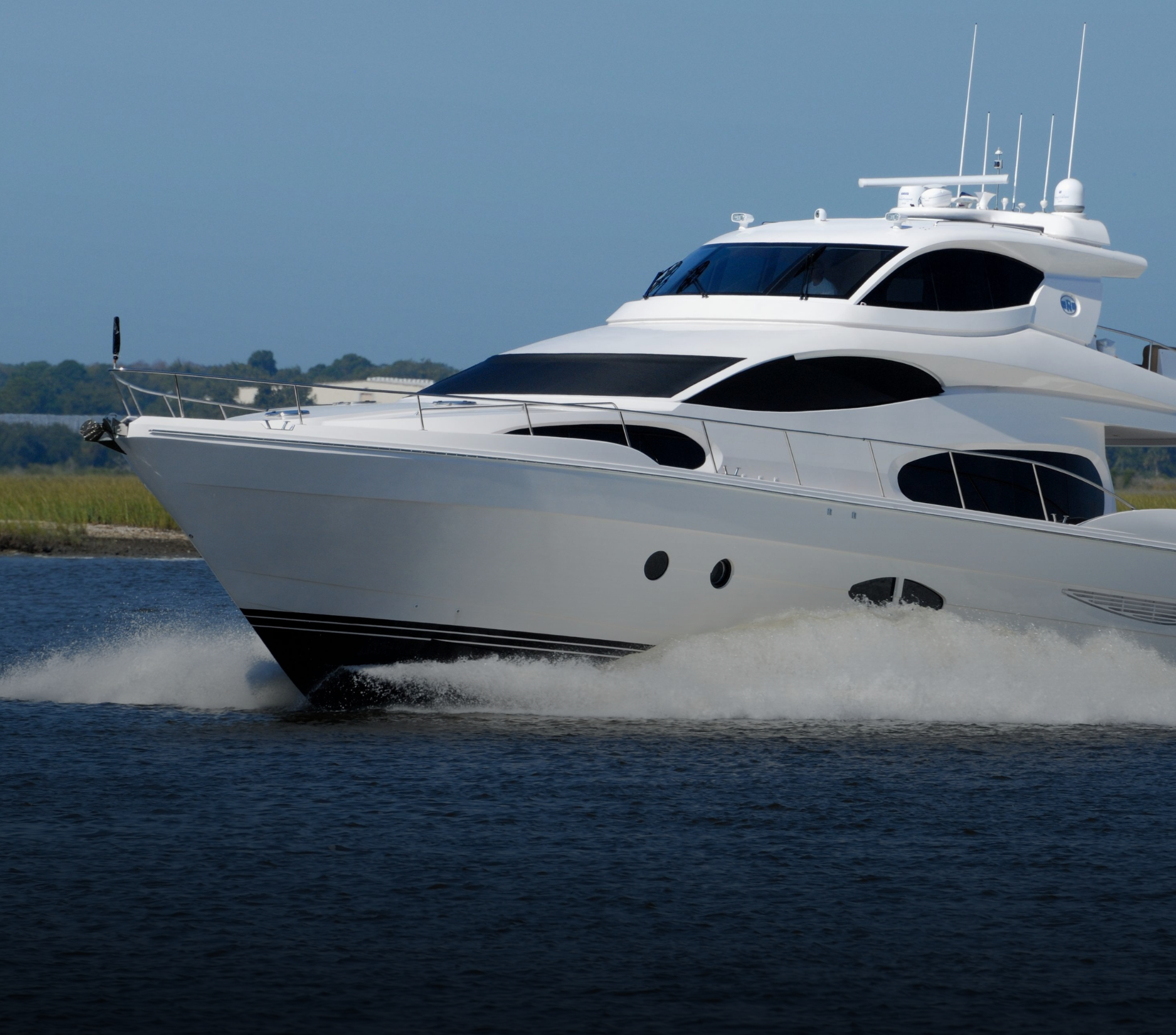 White yacht speeding across blue water.