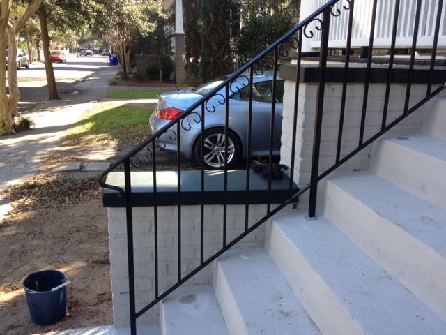 A car is parked on the side of the road next to a set of stairs