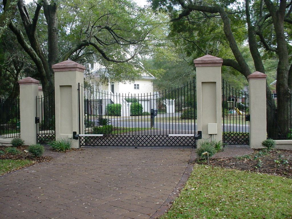 A wrought iron gate is open in front of a house