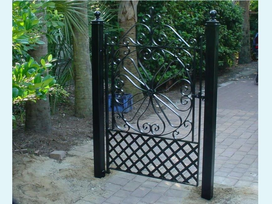 A wrought iron gate is sitting on a brick walkway