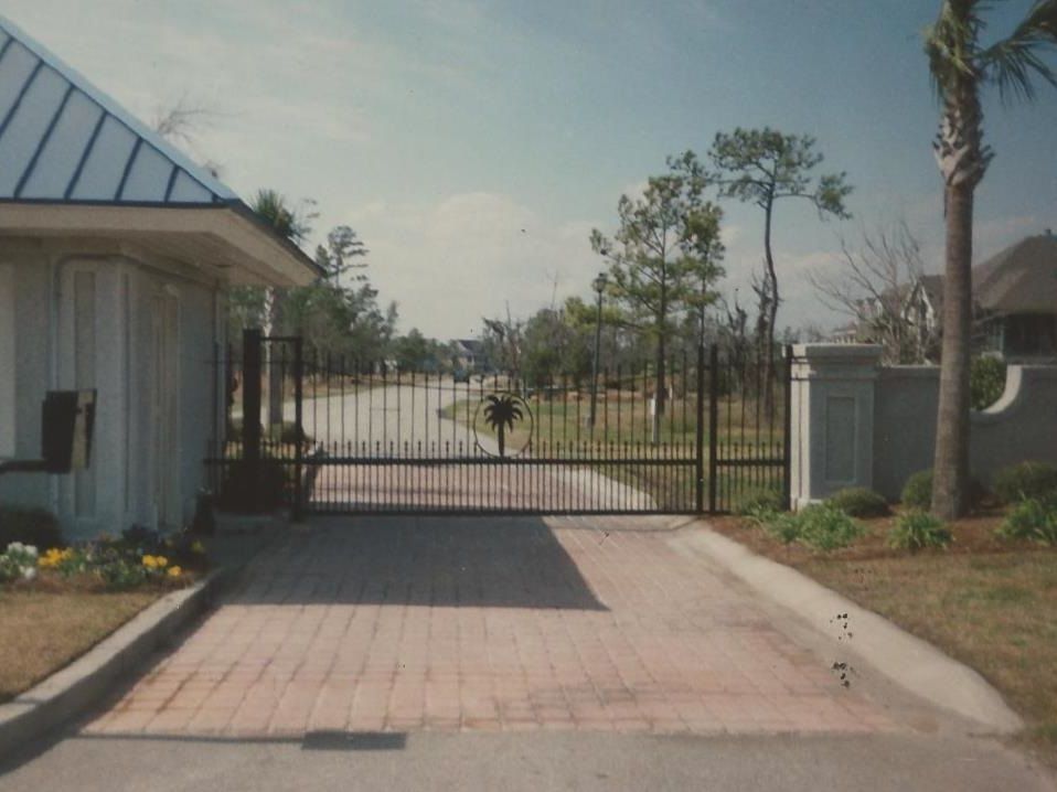 A brick driveway with a gate in the middle of it
