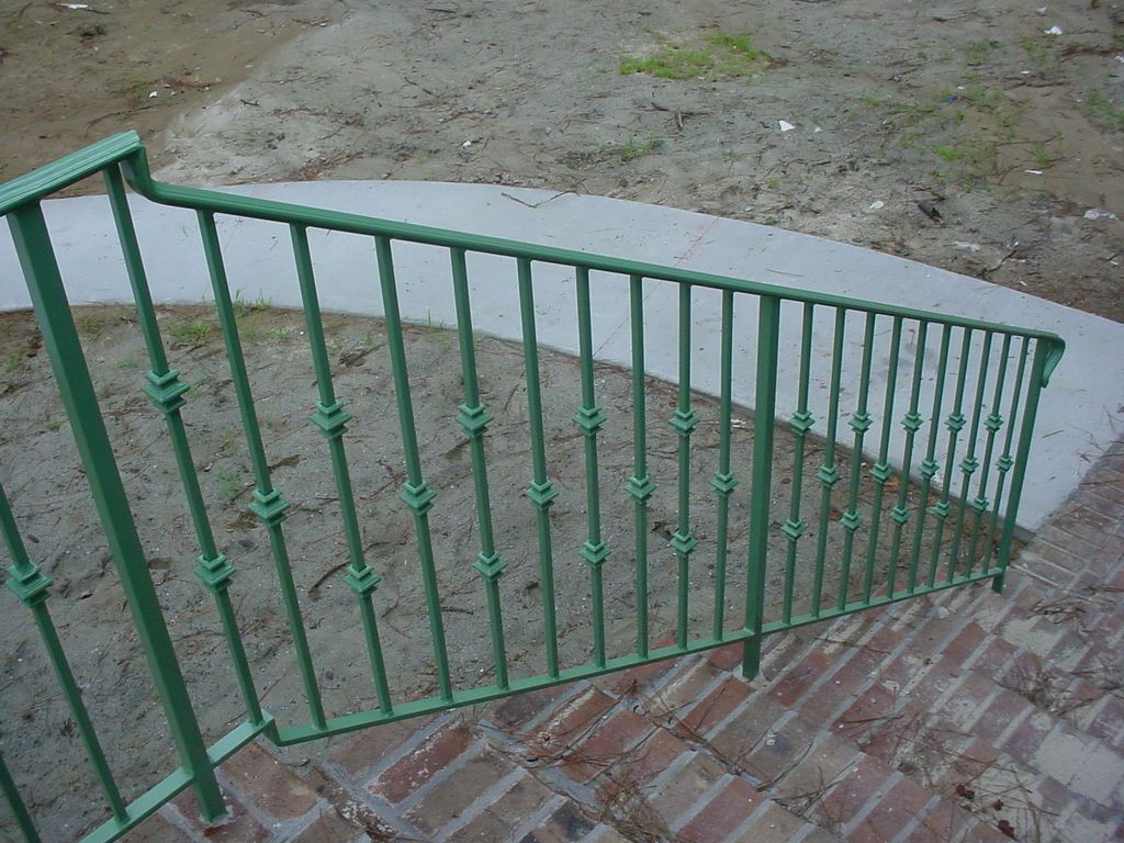 A green railing on a set of stairs