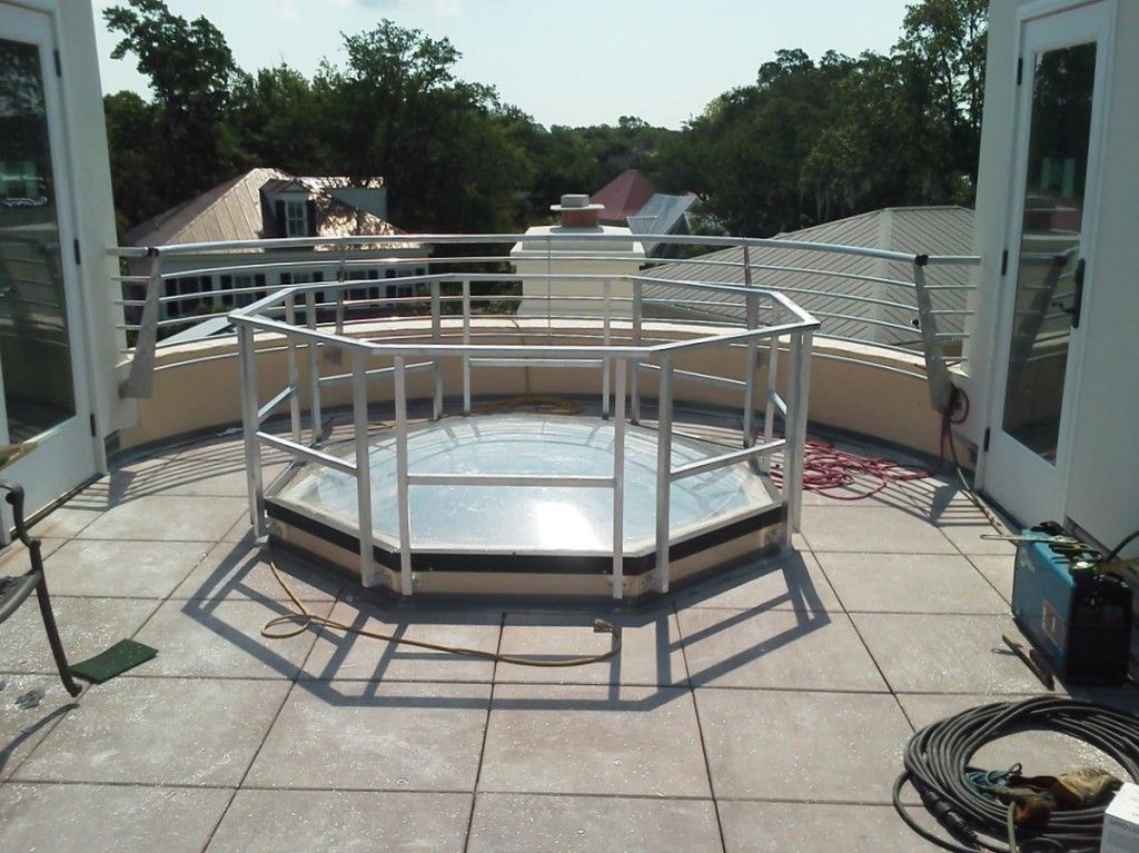 A hot tub on a rooftop with a fence around it