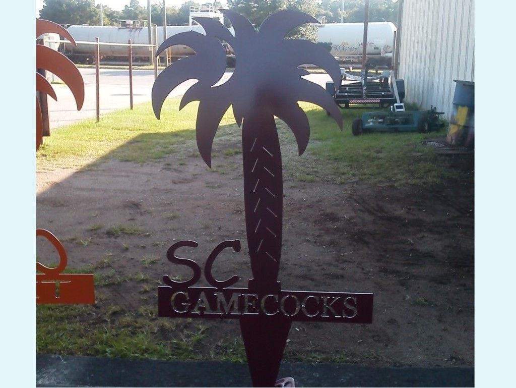 A palm tree made of copper metal. There is text on the tree that says SC Game Cocks