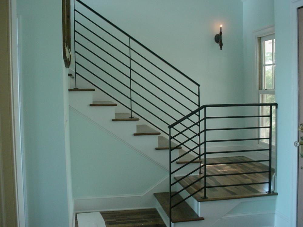 A staircase with a black railing and wooden steps