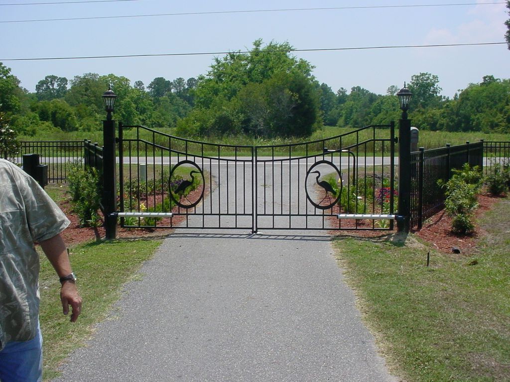 A man standing in front of a gate with a bird on it