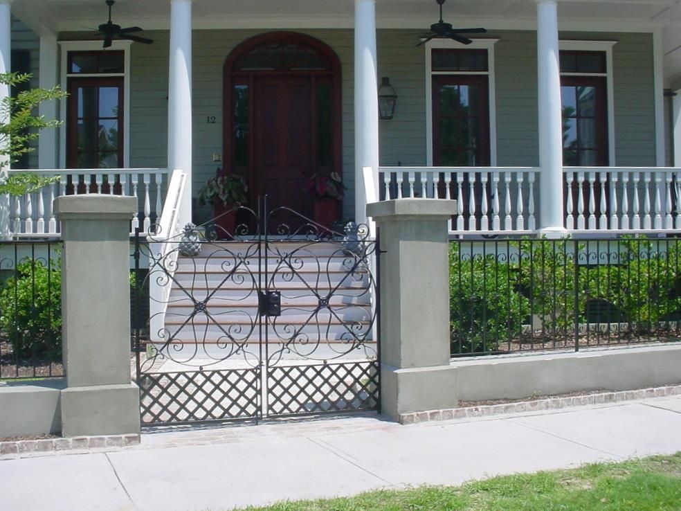 The front of a house with a wrought iron gate and stairs